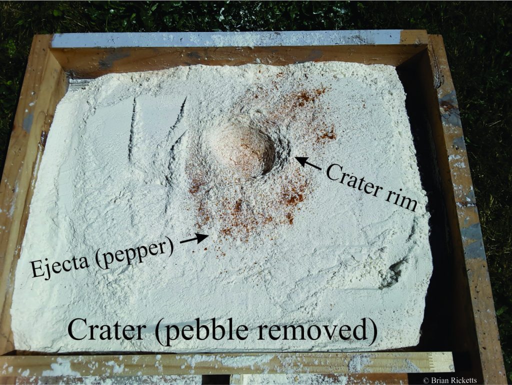 Another experiment, with a different spread of re pepper from the impact. The pebble (meteorite) has been removed.