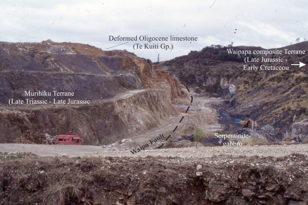 A terrane boundary, central North Island (New Zealand) marked by intrusion of subcrustal – upper mantle serpentinite (exposed in the quarry excavation), was originally harzburgite, and part of the Dun Mountain ophiolite Terrane, that separates intensely deformed Waipapa Terrane accretionary prism greywackes (right) from weakly deformed Murihiku Terrane sandstone and shale. Here, the Dun Mountain Terrane is wafer-thin.