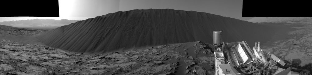 A composite image by Mars Curiosity Rover (December 2015) showing the steep front of a large dune that is advancing towards the camera. The streaky forms down the lee face were caused by small sand avalanches – probably grain flows. The dune is about 4m high. It is advancing about 1m per year. Image credits: NASA/JPL-Caltech/MSSS 