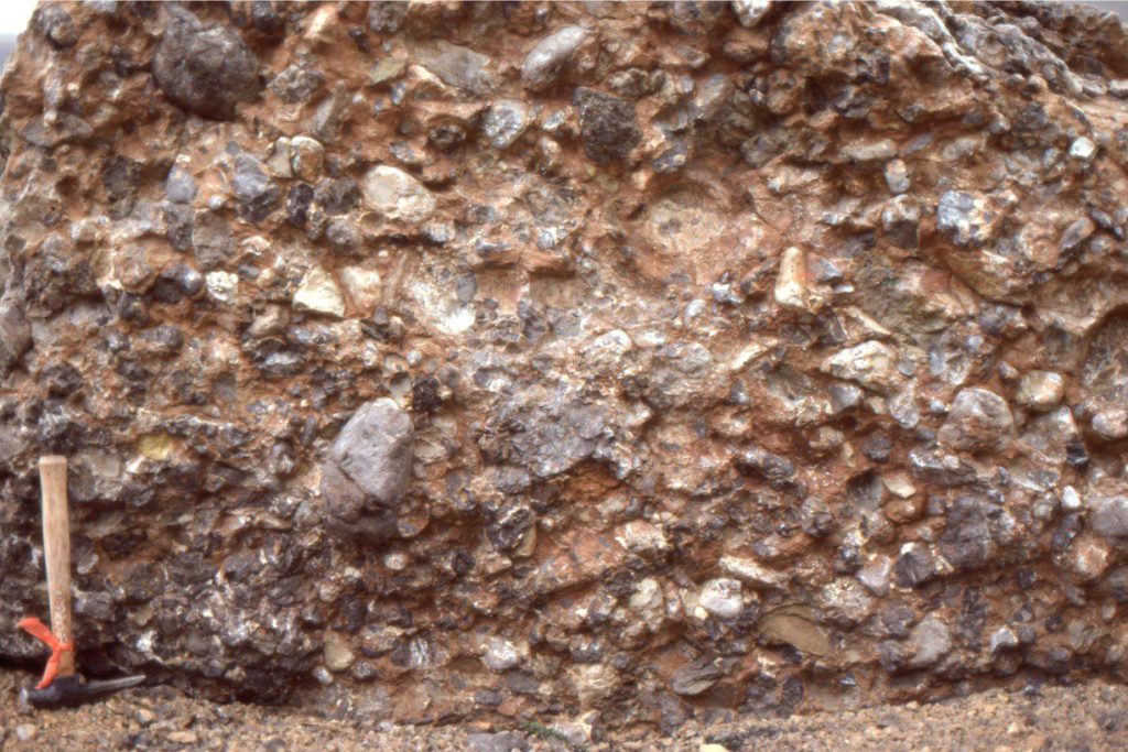 A massive conglomerate of probable fluvial origin, but lacking obvious crossbedding. Framework is clast-supported but sorting is extremely poor, with clasts ranging from small pebbles to 150+ mm diameter. The conglomerate is interbedded with other coarse-grained, crossbedded units. Buchanan Lake Fm, Ellesmere Island (?Eocene).