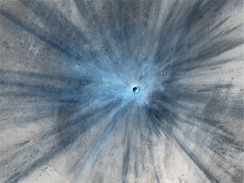 HiRISE has imaged several recent impacts on Mars surface. This one was acquired on November 19, 2013 – images of the site between 2010 and 2012 bracket the impact timing. The crater is 30 m diameter. Impact resulted in a spectacular ray-like zone of ejecta that spreads up to 15 km from the site and partly covers an extensive sand dune field. Image credit: NASA/JPL-Caltech/Univ. of Arizona