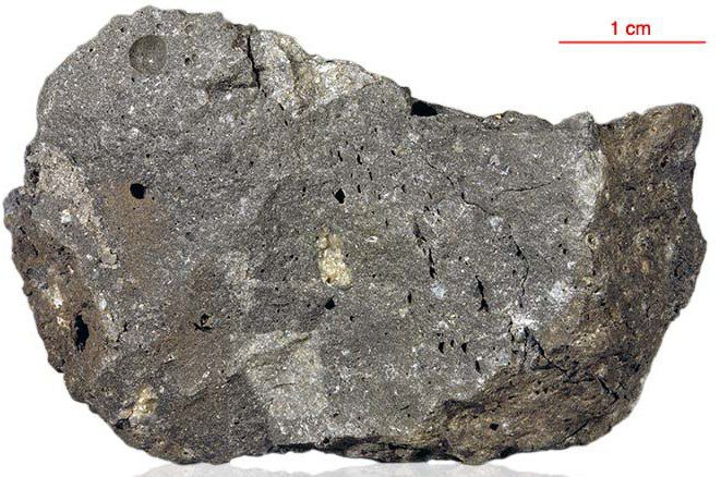 A sample (#72435) of fine-grained impact breccia from shallow regolith, collected by Apollo 17 astronauts. It contains several small fragments of bedrock and probably earlier formed regolith, welded by impact-melt glass. Vesicles indicate the release of volatiles during the high-temperature impact event. Reworked minerals like plagioclase, olivine and pyroxene commonly feature shock metamorphic textures. Ar/Ar dating of an included fragment yielded an age of 3.86±0.04 billion years. Image credit: Original image from NASA